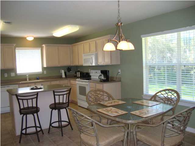 134 East Shipwreck Road Santa Rosa Beach, FL 32459 - Photo 10 of 23 a kitchen with stainless steel appliances granite countertop a stove a sink a stove a dining table and chairs