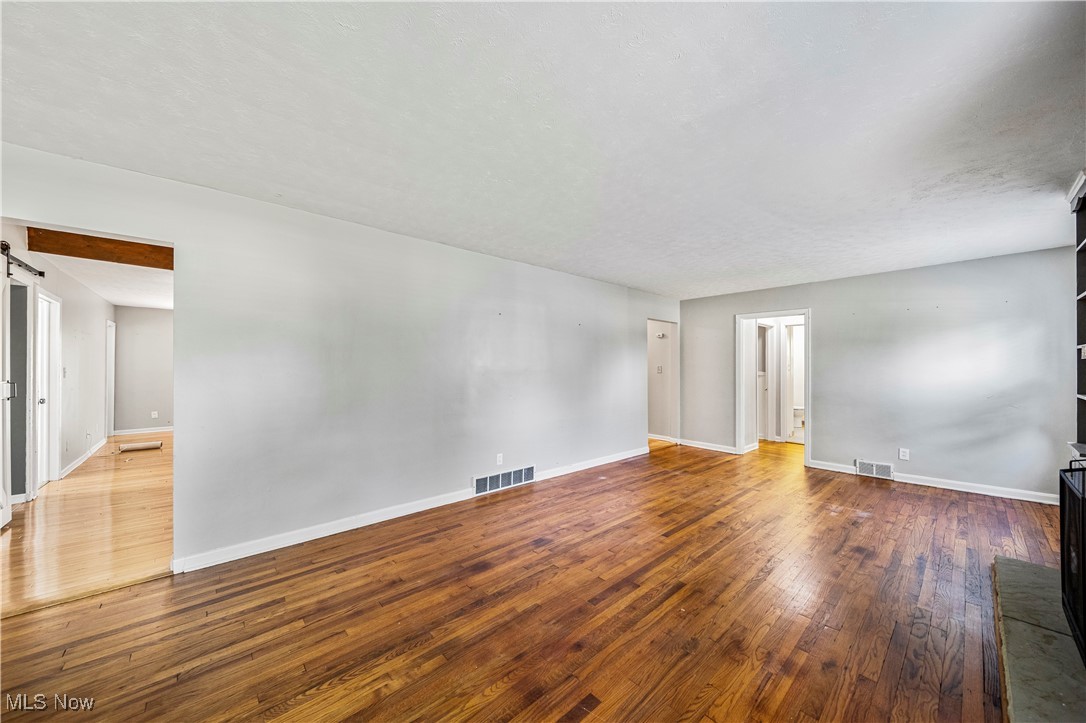 1796 Lander Road Mayfield Heights, OH 44124 - Photo 6 of 39 Unfurnished room with a barn door and dark hardwood / wood-style flooring