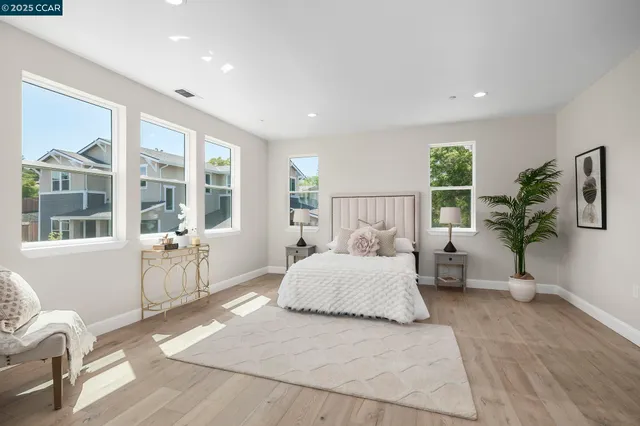 a bedroom with a large bed and windows