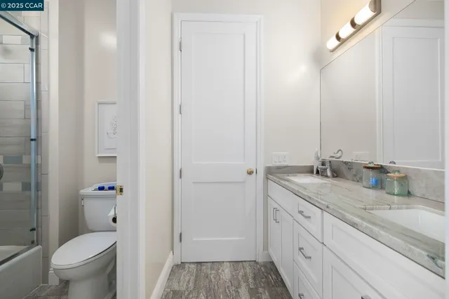 a bathroom with a granite countertop sink toilet and shower