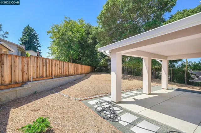 a view of backyard with green space and wooden fence