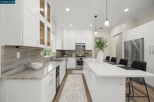 a kitchen with a sink a kitchen island and stainless steel appliances
