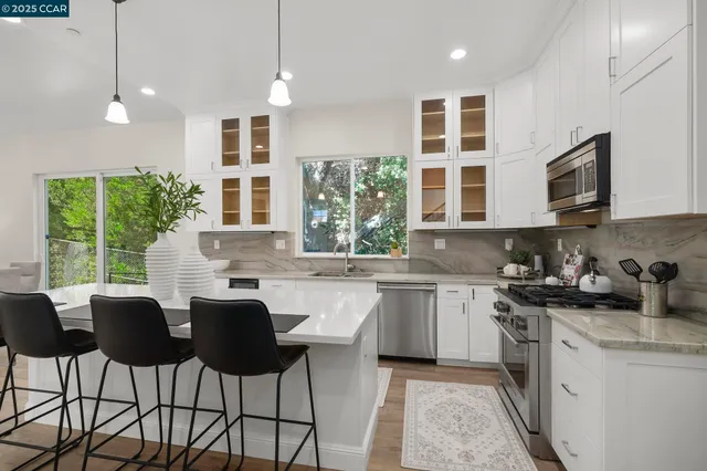 a kitchen with kitchen island granite countertop a sink and white cabinets