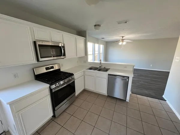 a kitchen with a stove a sink and a microwave