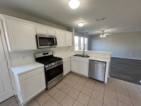 a kitchen with a sink stove and microwave