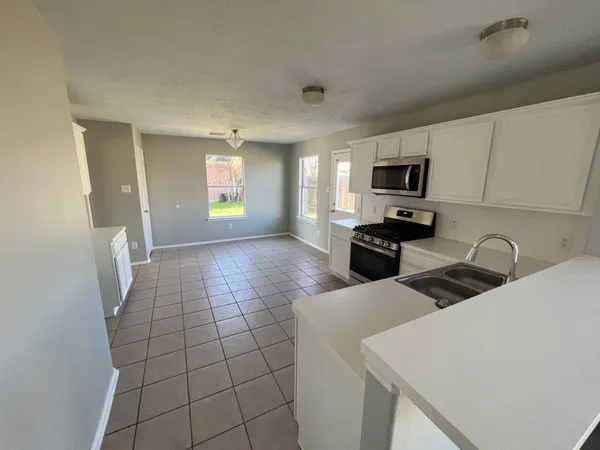 a kitchen with a sink a microwave and cabinets