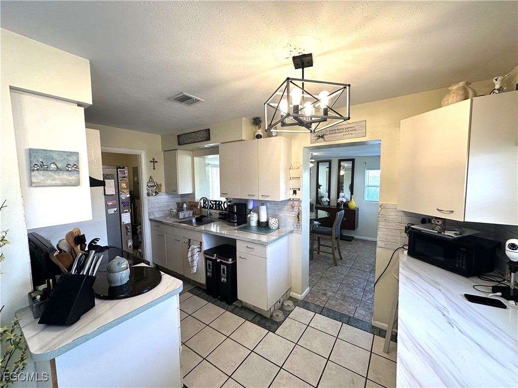 100 Davis Road Lehigh Acres, FL 33936 - Photo 5 of 32 a kitchen with a table and chairs
