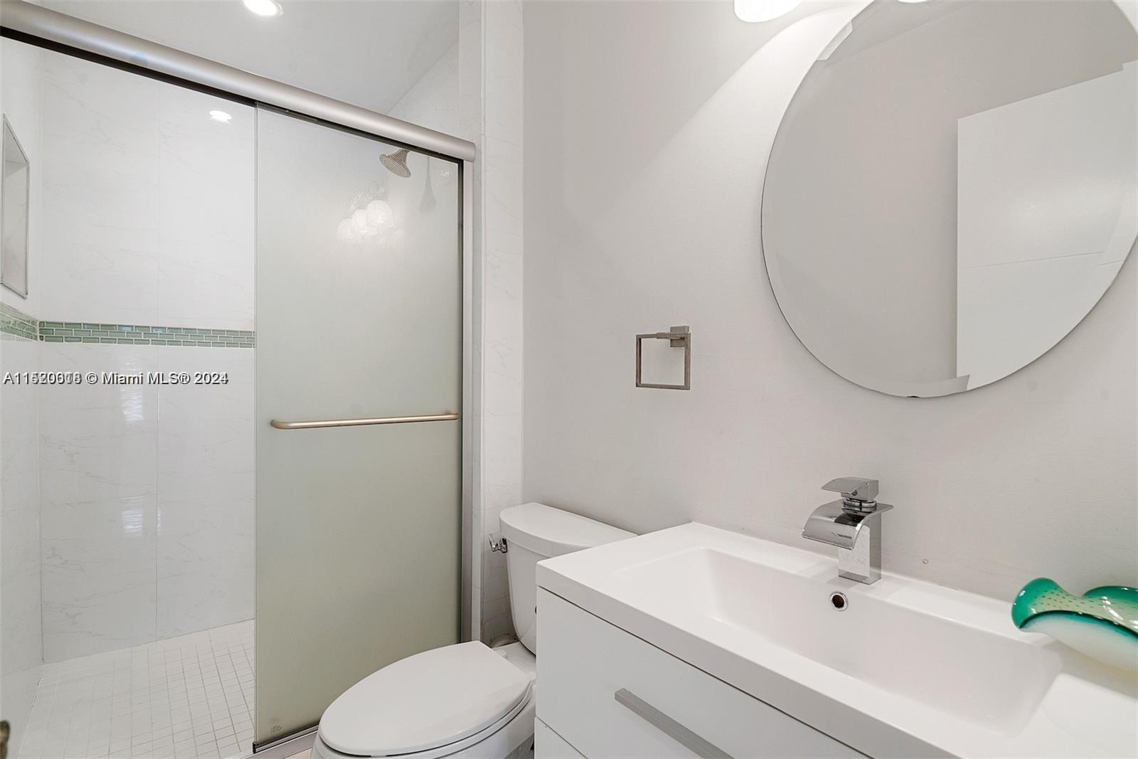5250 Alton Road Miami Beach, FL 33140 - Photo 17 of 30 a bathroom with a sink and a mirror