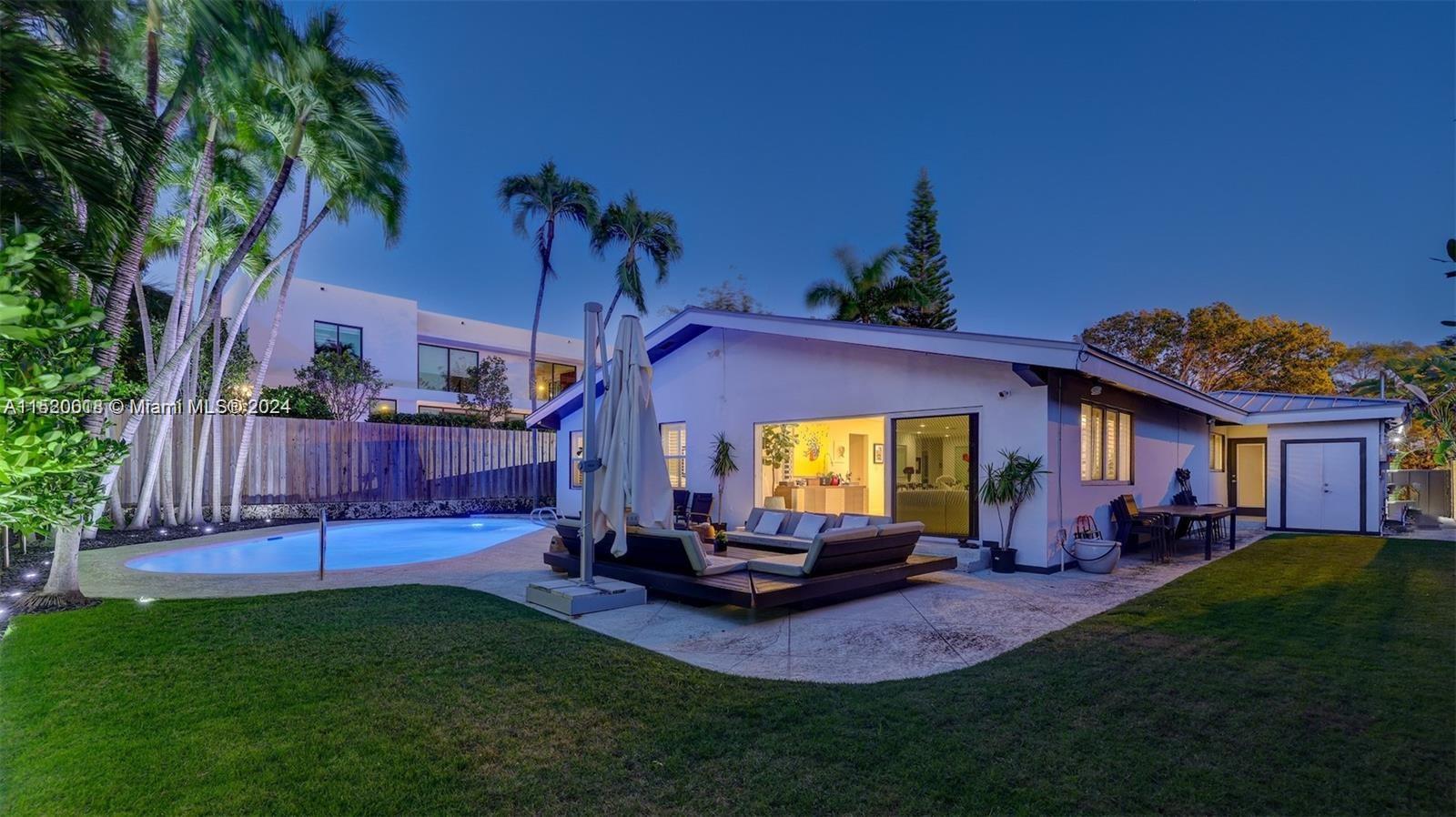 5250 Alton Road Miami Beach, FL 33140 - Photo 23 of 30 a view of a house with a swimming pool and a yard