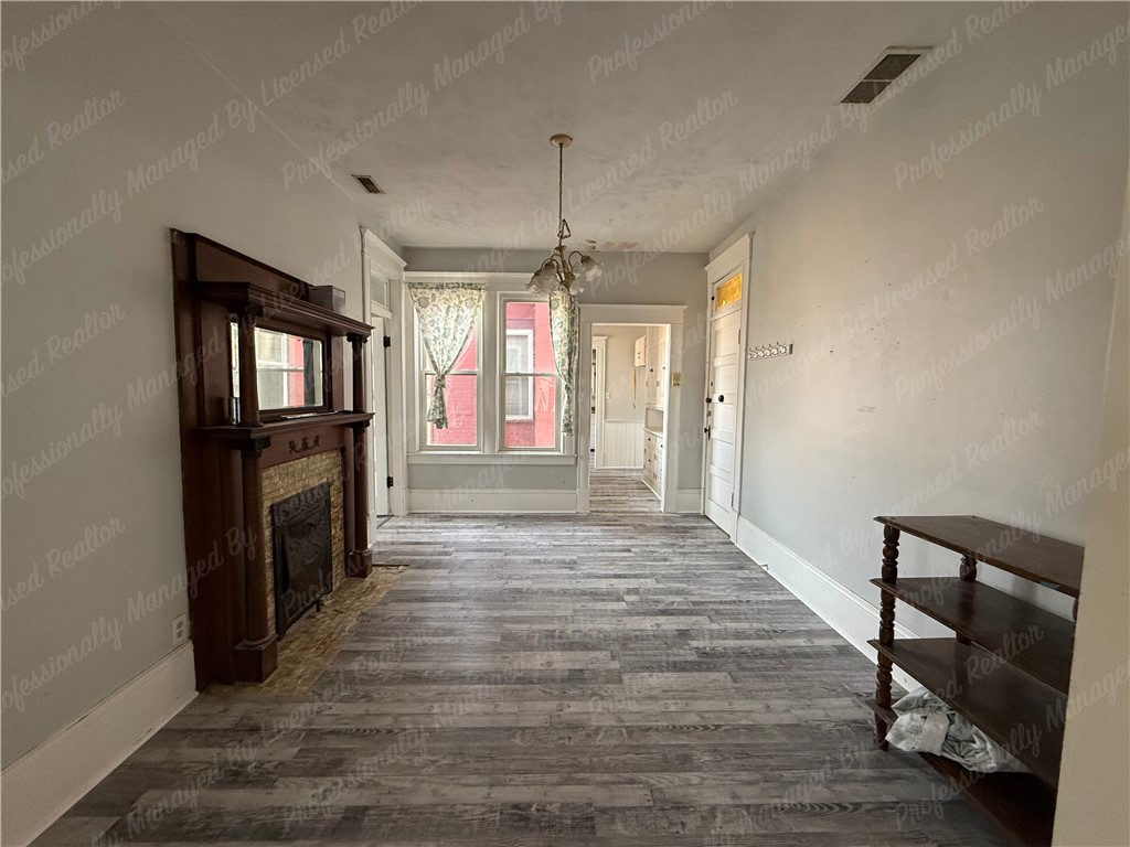 44 West High Street, Unit D Springfield, OH 45502 - Photo 8 of 25 This inviting room features elegant flooring and a classic fireplace, creating a warm ambiance.