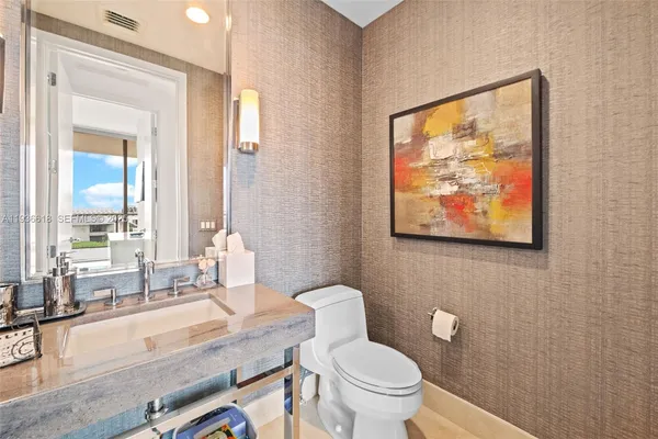 a bathroom with a granite countertop sink and a large mirror