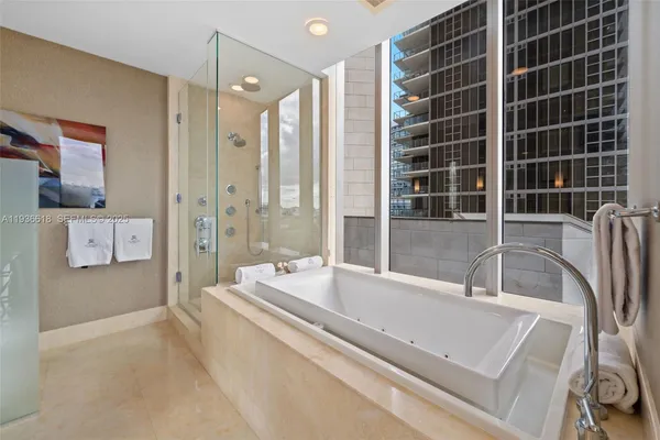 a spacious bathroom with a tub a double vanity sink a shower and a mirror