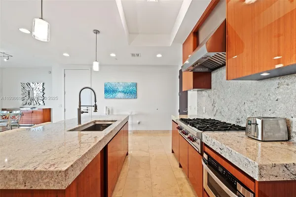 a kitchen with stainless steel appliances granite countertop a sink stove and cabinets