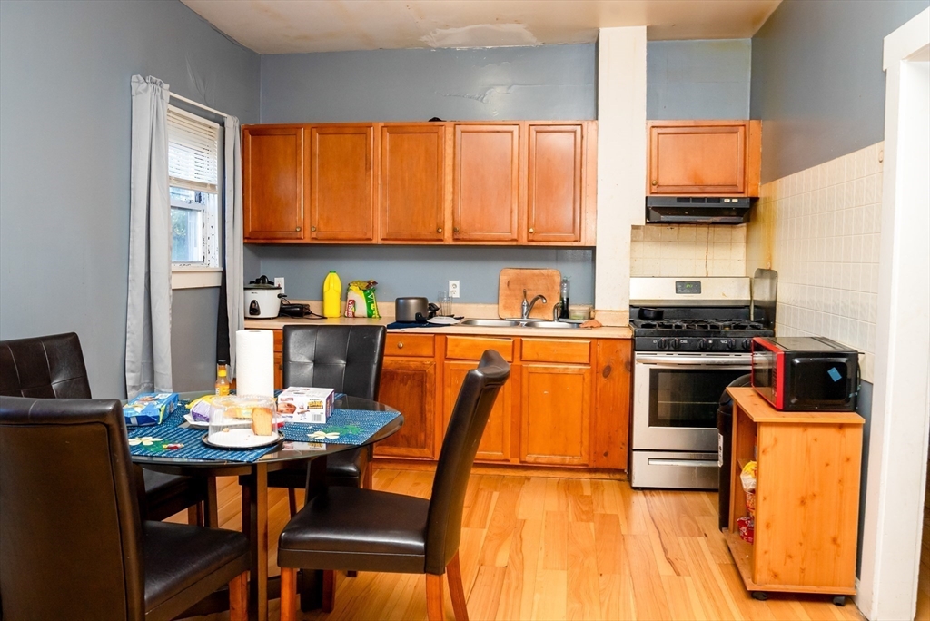 118 Jefferson Street Fall River, MA 02721 - Photo 21 of 34 a kitchen with a sink a stove and chairs