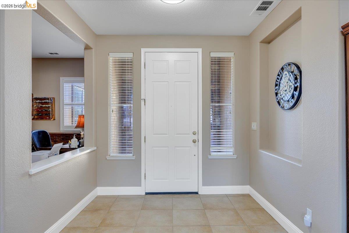 158 Rock Ridge Lane Copperopolis, CA 95228 - Photo 9 of 72 Entryway featuring a paneled door, two vertical windows with blinds, and tile flooring