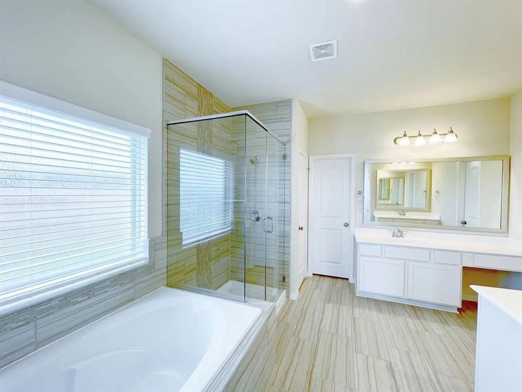 4403 Silvergrass Lane Katy, TX 77493 - Photo 14 of 26 a bathroom with a sink a mirror and a bathtub