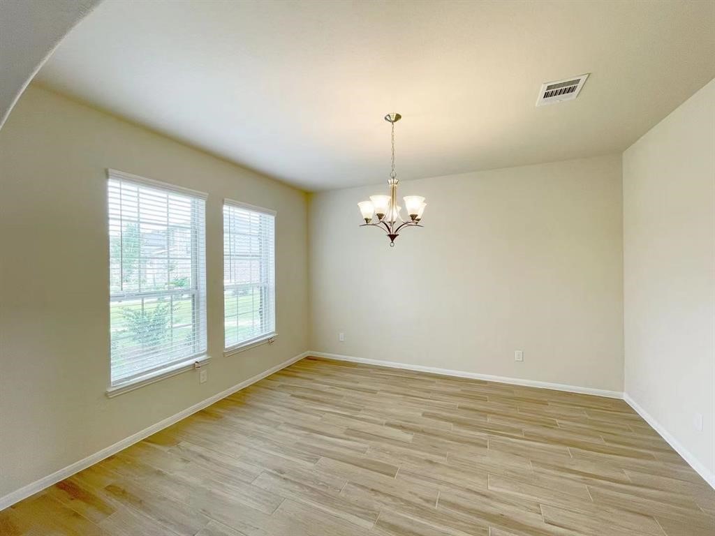 4403 Silvergrass Lane Katy, TX 77493 - Photo 3 of 26 wooden floor in an empty room with a window