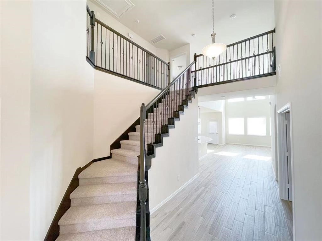 4403 Silvergrass Lane Katy, TX 77493 - Photo 4 of 26 a view of staircase with wooden floor and white walls