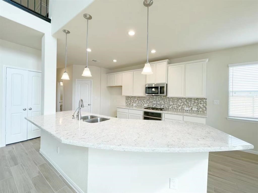 4403 Silvergrass Lane Katy, TX 77493 - Photo 9 of 26 a kitchen with kitchen island a sink stainless steel appliances and cabinets