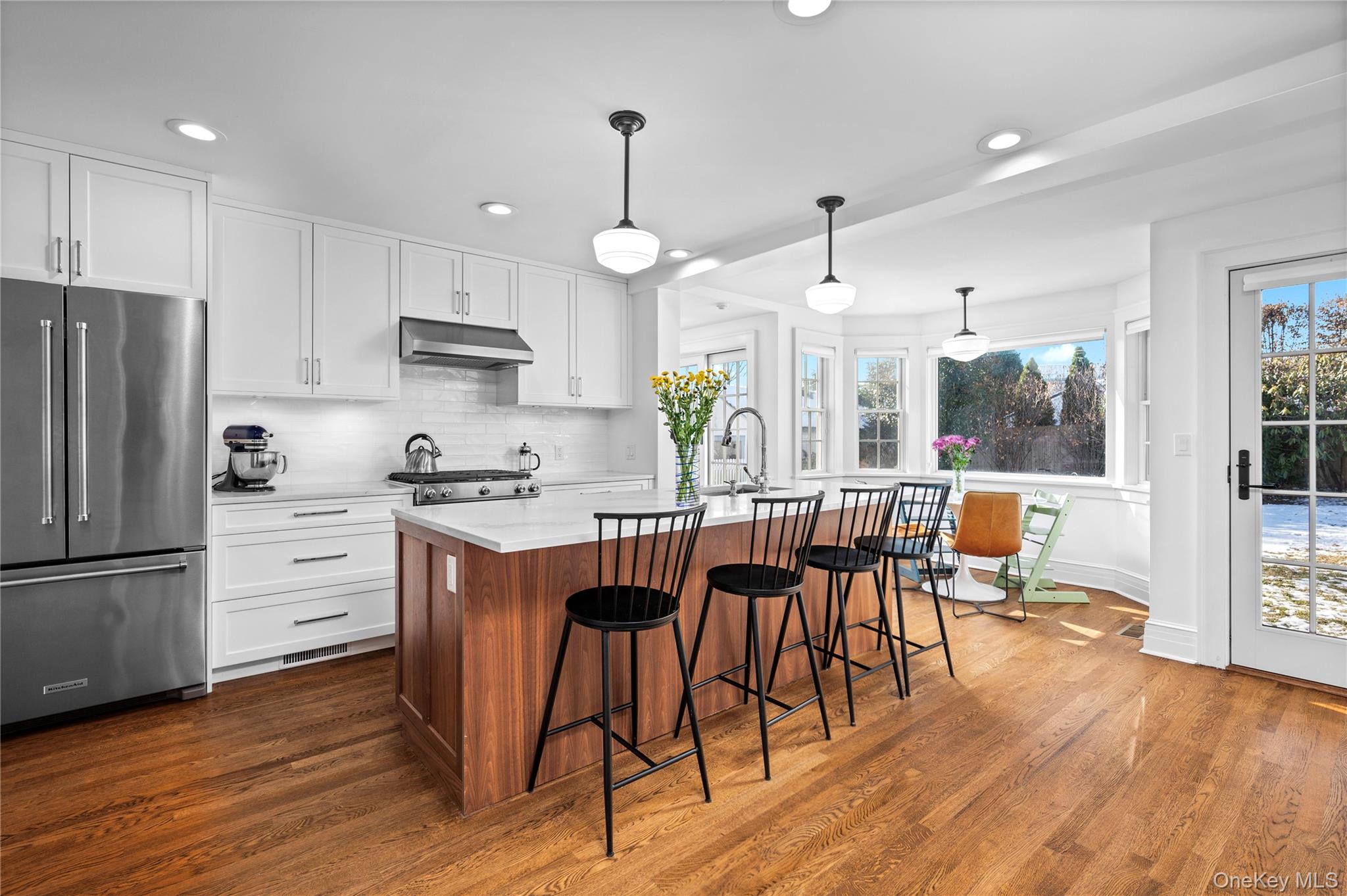 123 Ellison Avenue Bronxville, NY 10708 - Photo 3 of 27 a kitchen with stainless steel appliances a dining table chairs stove refrigerator and cabinets