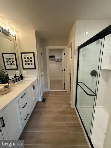 a bathroom with double vanity and a shower