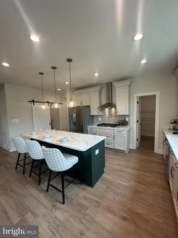 a kitchen with stainless steel appliances granite countertop a table chairs sink and cabinets