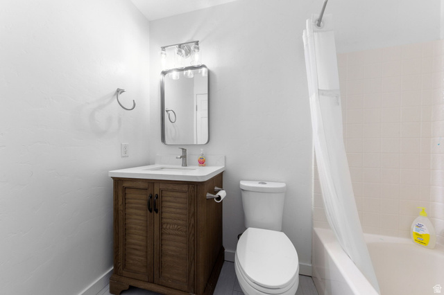 664 East Springhill Drive Washington, UT 84780 - Photo 10 of 21 Bathroom featuring a wood-finish vanity with louvered doors, a rectangular undermount sink, and a white countertop