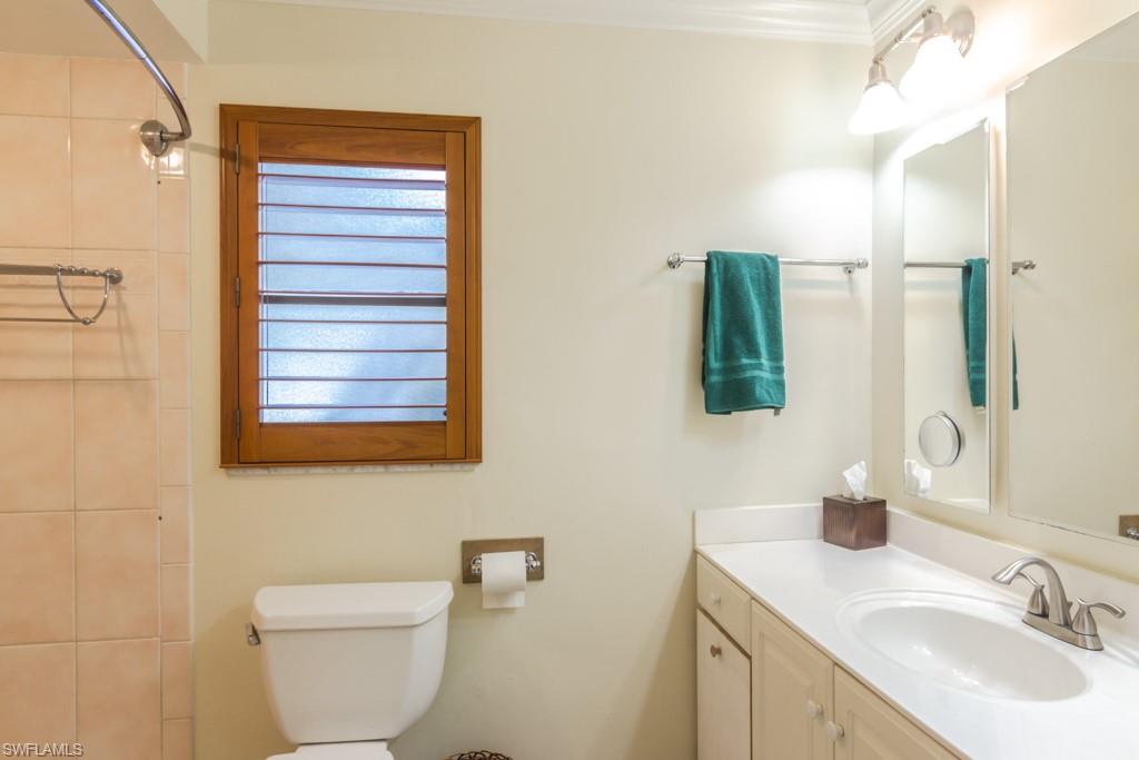 4525 North Road Naples, FL 34104 - Photo 11 of 33 a bathroom with a toilet sink and mirror