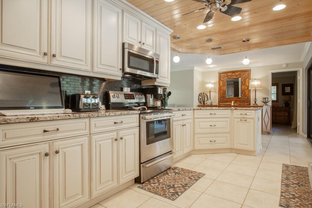 4525 North Road Naples, FL 34104 - Photo 7 of 33 a kitchen with stainless steel appliances granite countertop a sink a stove and cabinets