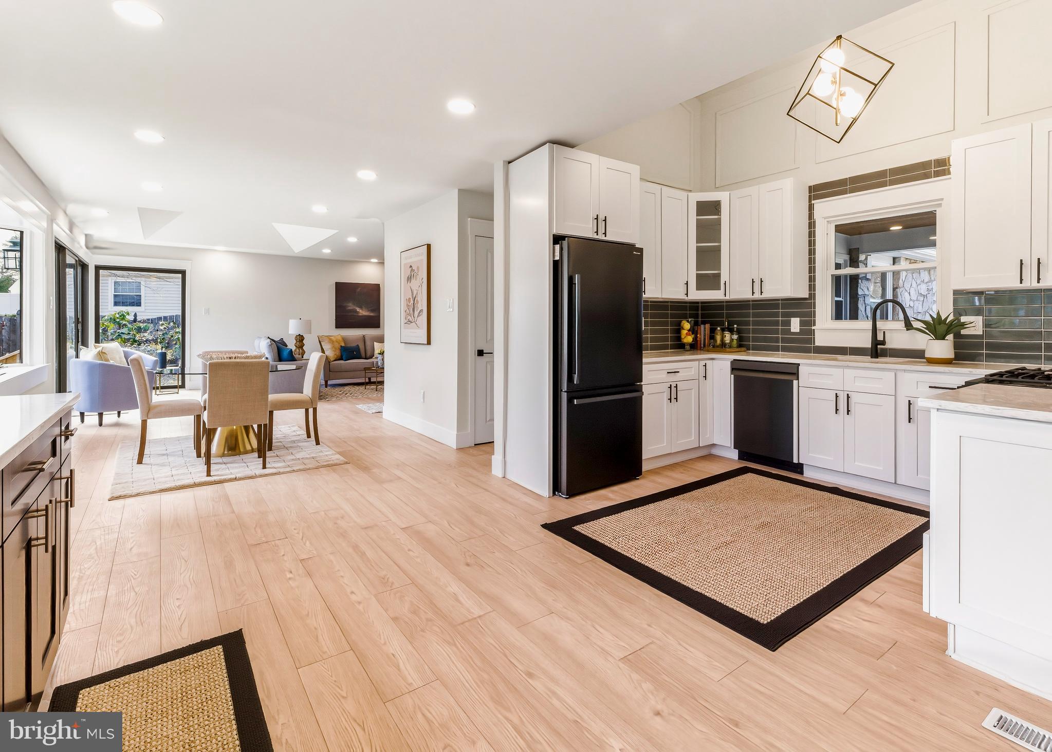 451 Alcyon Boulevard Pitman, NJ 08071 - Photo 7 of 32 a kitchen with stainless steel appliances granite countertop a refrigerator a stove top oven a sink dishwasher and white cabinets with wooden floor