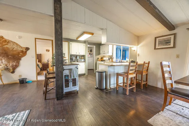 a kitchen with stainless steel appliances granite countertop a stove a sink dishwasher and white cabinets with wooden floor