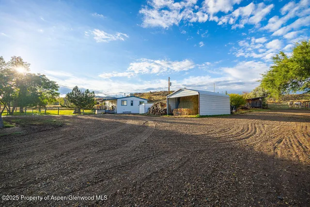 an aerial view of residential houses with outdoor space and trees