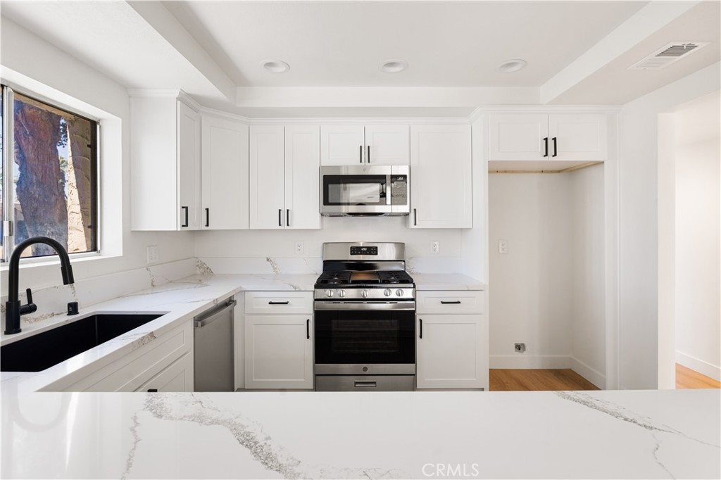 82151 Waring Way Indio, CA 92201 - Photo 11 of 22 a kitchen with stainless steel appliances a stove a sink and a refrigerator