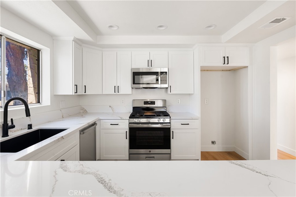 82151 Waring Way Indio, CA 92201 - Photo 13 of 22 a kitchen with stainless steel appliances a stove a sink and a refrigerator