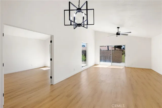 a view of empty room with wooden floor and ceiling fan