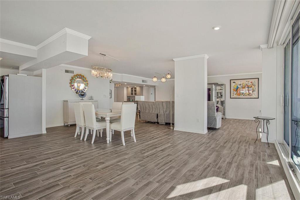 4031 Gulf Shore Boulevard North, Unit 6B Naples, FL 34103 - Photo 12 of 37 Dining space featuring wood finish floors, a chandelier, and ornamental molding