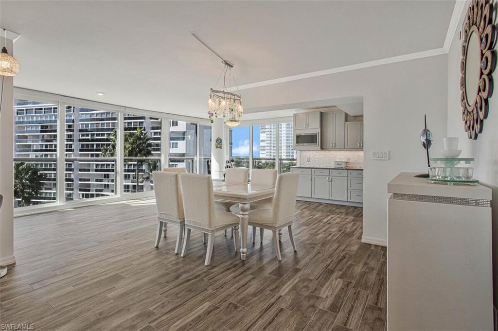 4031 Gulf Shore Boulevard North, Unit 6B Naples, FL 34103 - Photo 14 of 37 Dining room featuring a chandelier, dark wood-type flooring, and ornamental molding