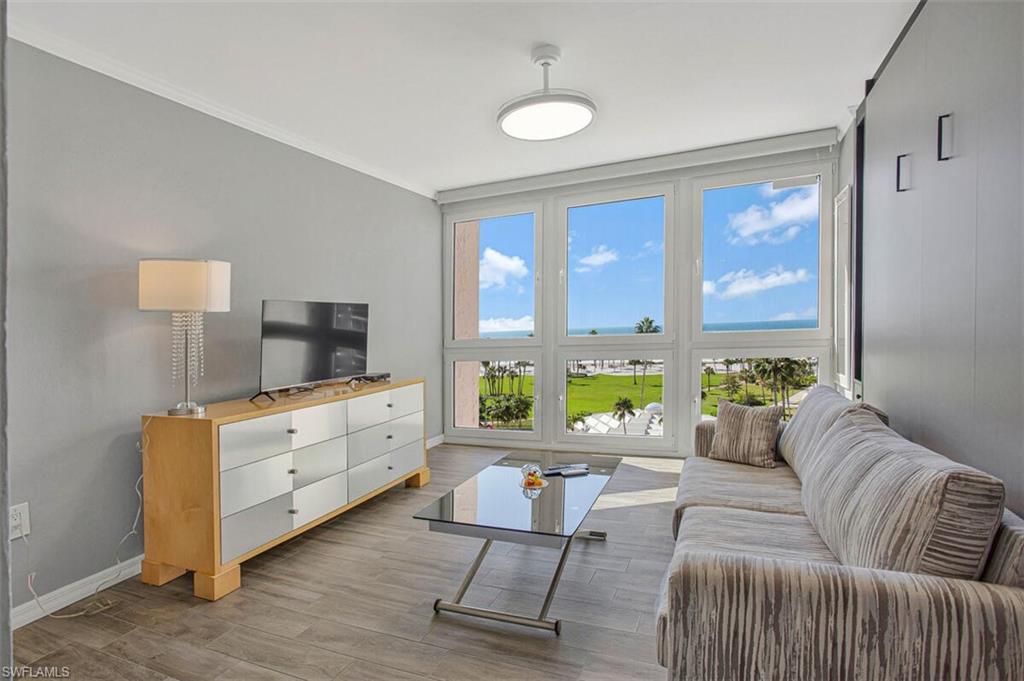 4031 Gulf Shore Boulevard North, Unit 6B Naples, FL 34103 - Photo 22 of 37 Living area with ornamental molding and wood finished floors
