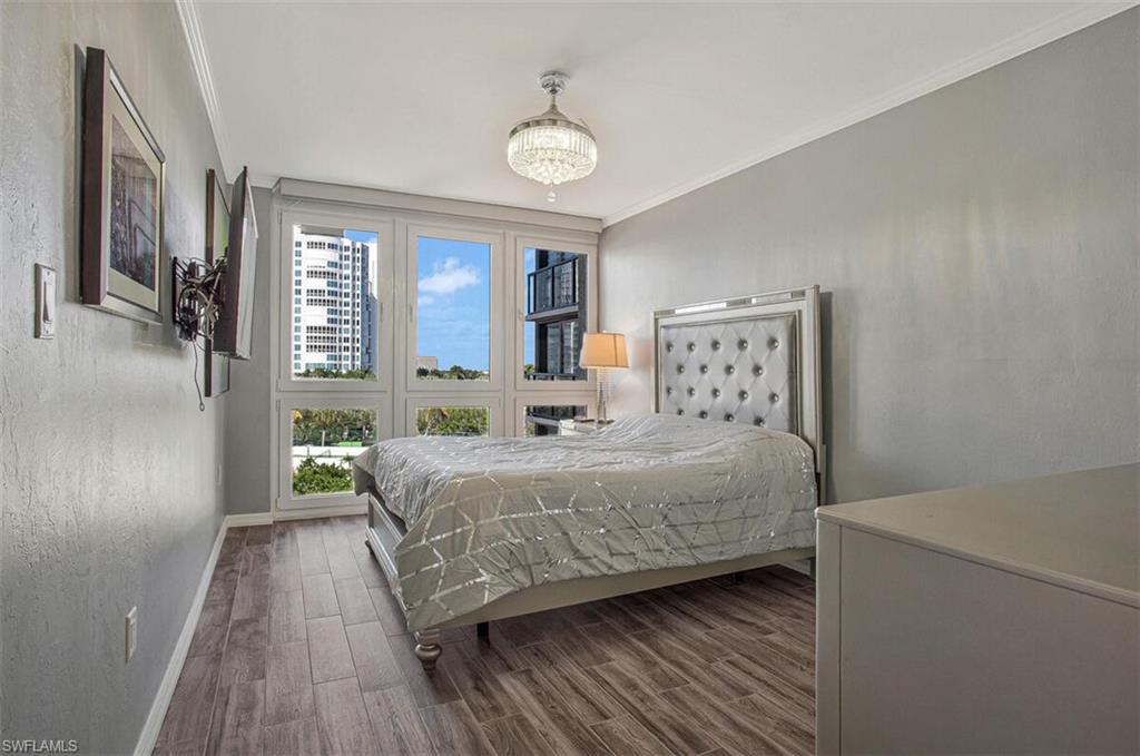 4031 Gulf Shore Boulevard North, Unit 6B Naples, FL 34103 - Photo 26 of 37 Bedroom with wood tiled floors, ornamental molding, and a chandelier