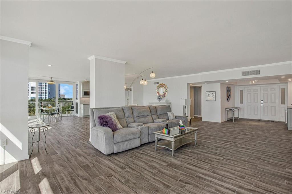 4031 Gulf Shore Boulevard North, Unit 6B Naples, FL 34103 - Photo 30 of 37 Living room featuring crown molding, dark wood-style floors, a wall of windows, and recessed lighting