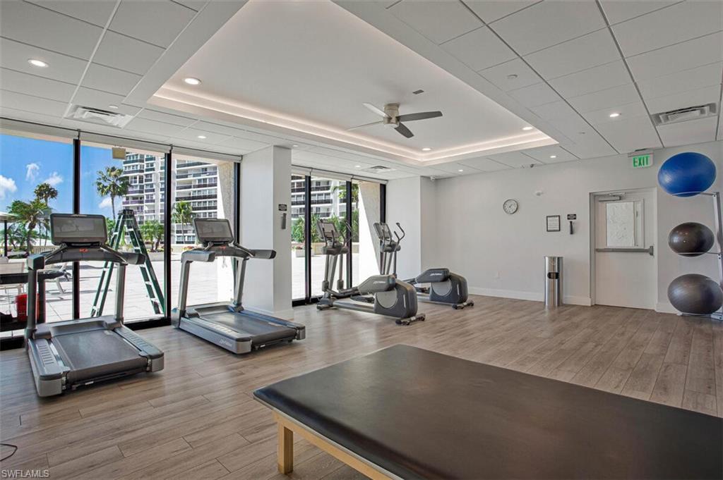 4031 Gulf Shore Boulevard North, Unit 6B Naples, FL 34103 - Photo 5 of 37 Exercise room featuring expansive windows, ceiling fan, and recessed lighting