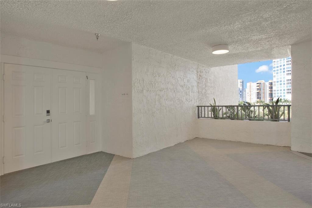 4031 Gulf Shore Boulevard North, Unit 6B Naples, FL 34103 - Photo 7 of 37 Carpeted spare room with a textured ceiling, a textured wall, and a city view