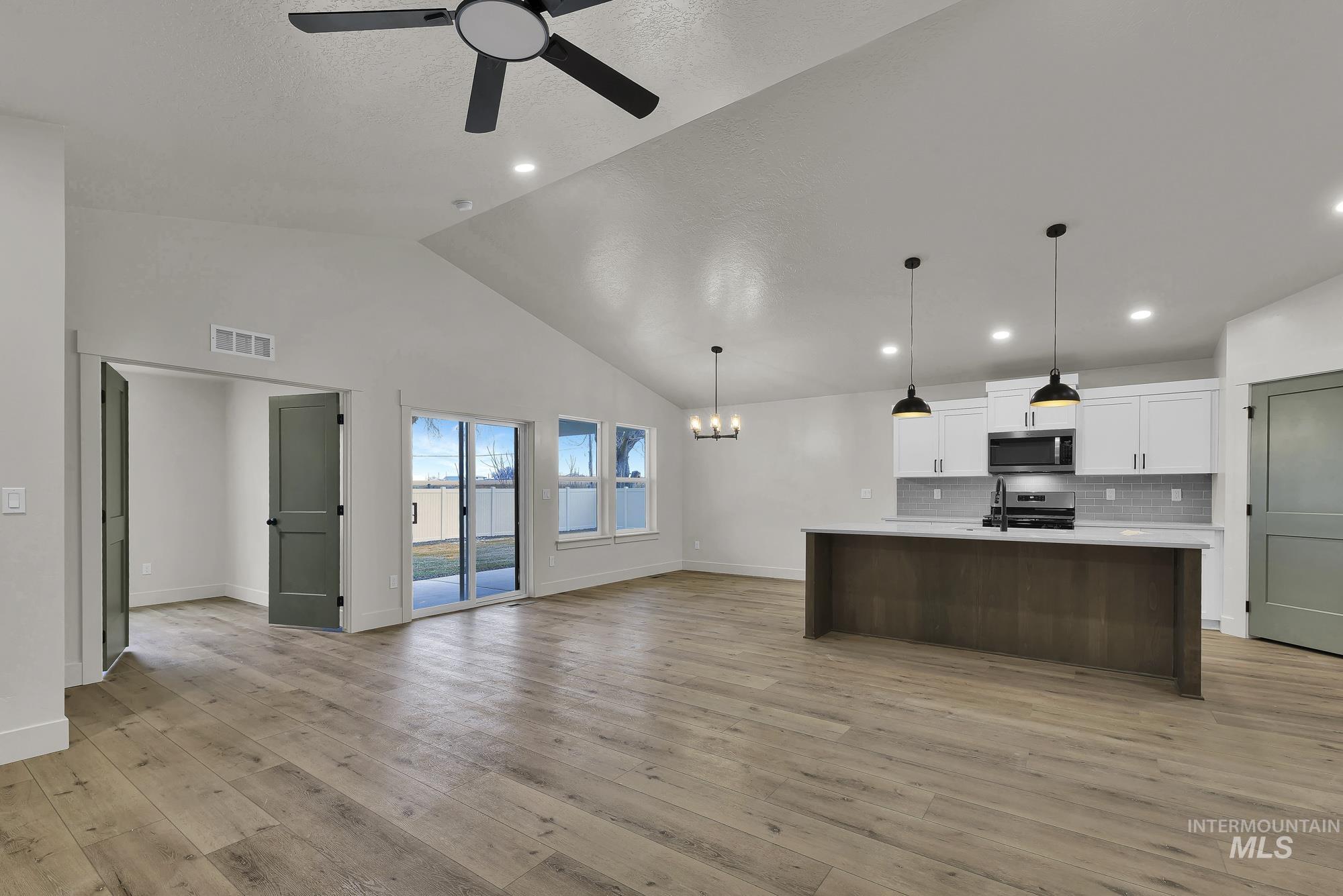 1130 Velvet Loop Wilder, ID 83676 - Photo 8 of 35 Vaulted ceiling with a ceiling fan over wood-finish flooring