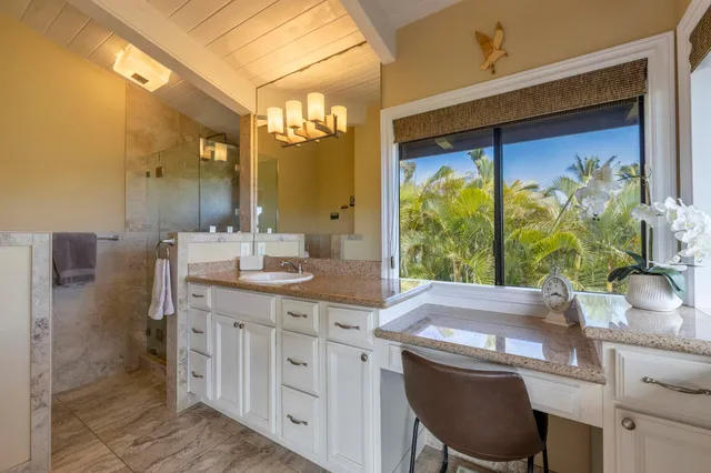 a bathroom with a granite countertop sink a large mirror and a shower