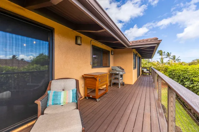 a view of a balcony with wooden floor and iron fence