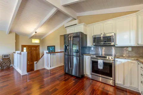 a kitchen with stainless steel appliances granite countertop a refrigerator microwave and stove top oven