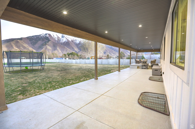 126 North 800 West Mapleton, UT 84664 - Photo 69 of 79 Fenced backyard with a mountain view, a patio area, and a trampoline