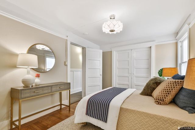a bedroom with a large bed and a chandelier