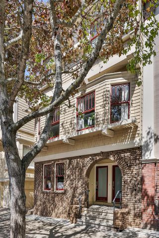 a front view of a house with large trees