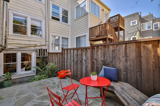 a view of a chair and tables in the back yard of the house